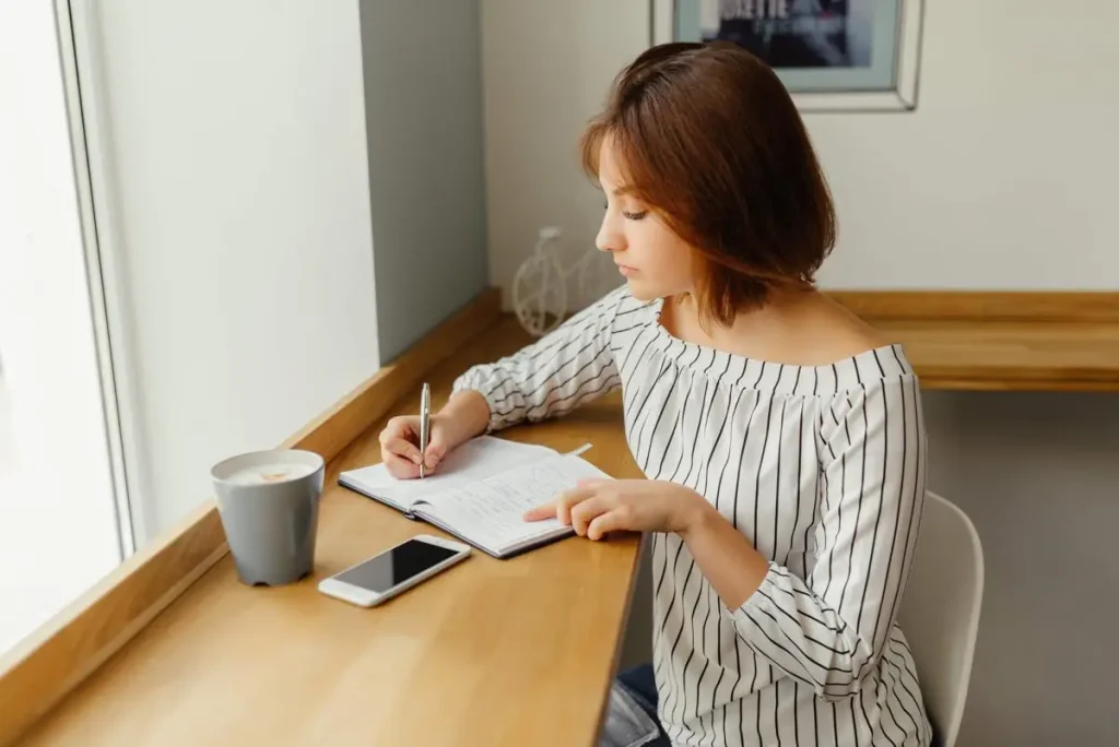 young-business-woman-sitting-cafe-table-use-smartphone-work-with-note-book_bde3225e-676e-438d-a0ac-8ecff91b2358